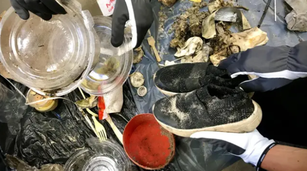 Bilden visar skräp som har plockats vid badstranden, ett par skor och olika plastföremål